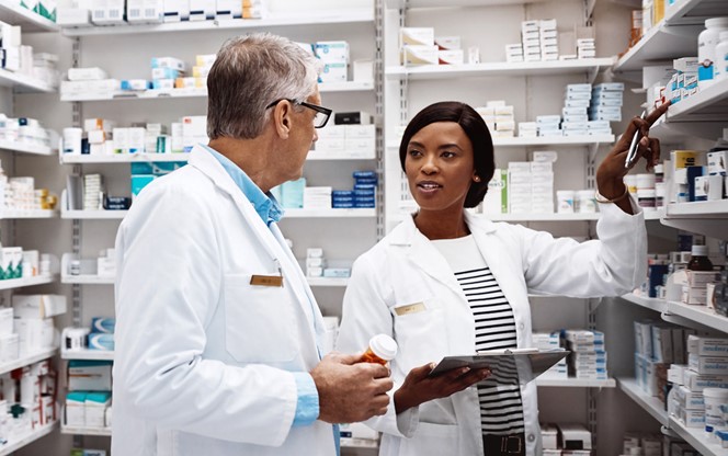 Two Pharmacists Working Together In A Drugstore