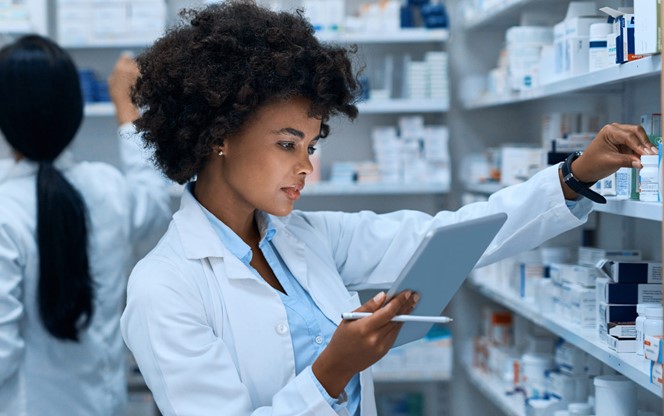 Female Pharmacist Doing Inventory On A Digital Tablet